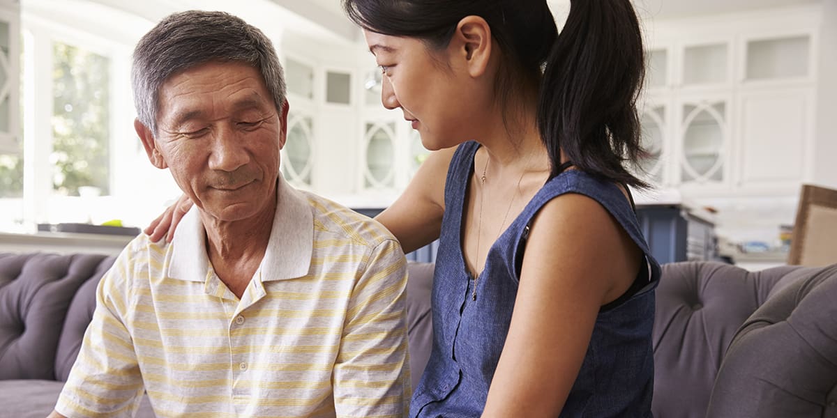 Adult Daughter Talking To Depressed Father At Home